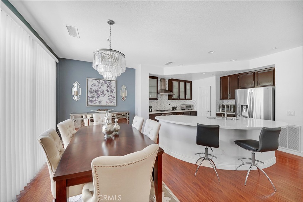 23 Carnation Irvine, CA 92618 - Photo 4 of 30 a view of a dining room with furniture a chandelier and wooden floor