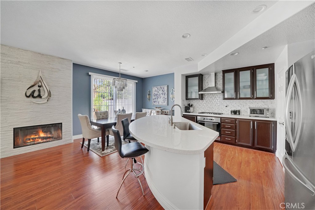 23 Carnation Irvine, CA 92618 - Photo 5 of 30 a open kitchen with stainless steel appliances granite countertop a stove a refrigerator a oven a sink with island and chairs with wooden floor