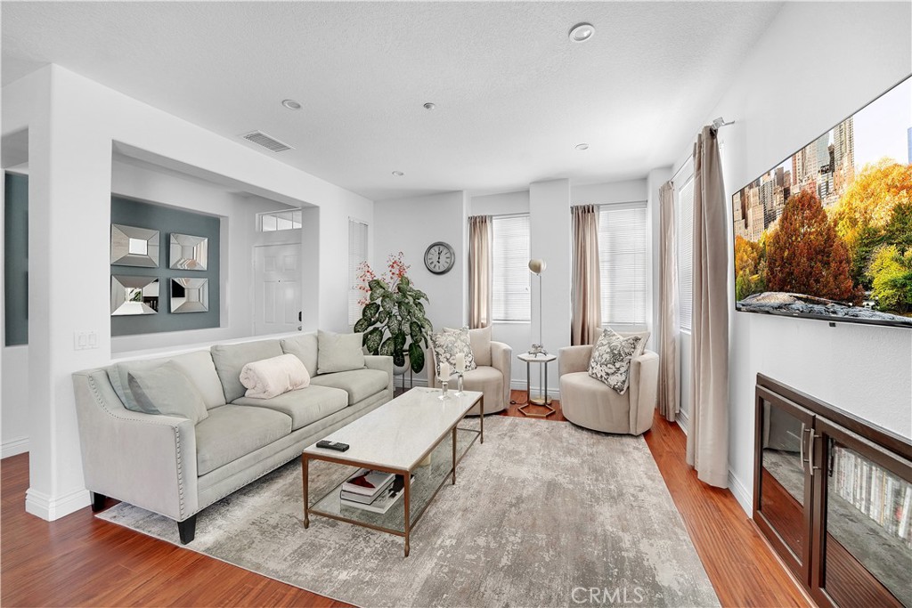 23 Carnation Irvine, CA 92618 - Photo 8 of 30 a living room with furniture a flat screen tv and a floor to ceiling window