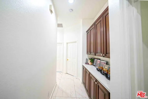 a living room with stainless steel appliances kitchen island granite countertop a refrigerator a stove a sink dishwasher and a dining table with wooden floor