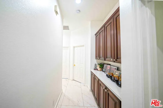 a living room with stainless steel appliances kitchen island granite countertop a refrigerator a stove a sink dishwasher and a dining table with wooden floor