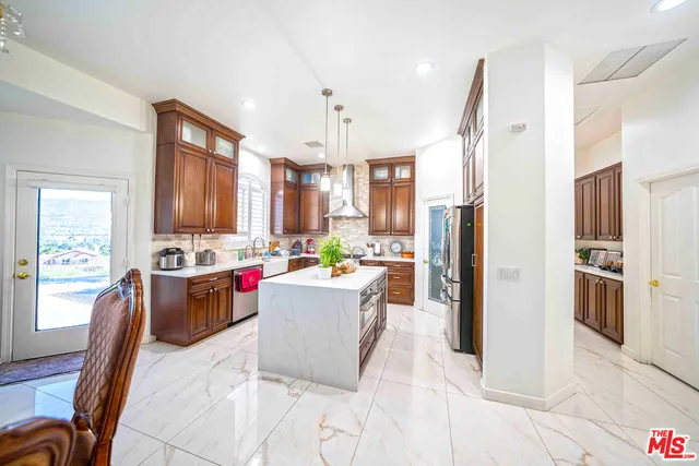 a kitchen with kitchen island white cabinets and stainless steel appliances