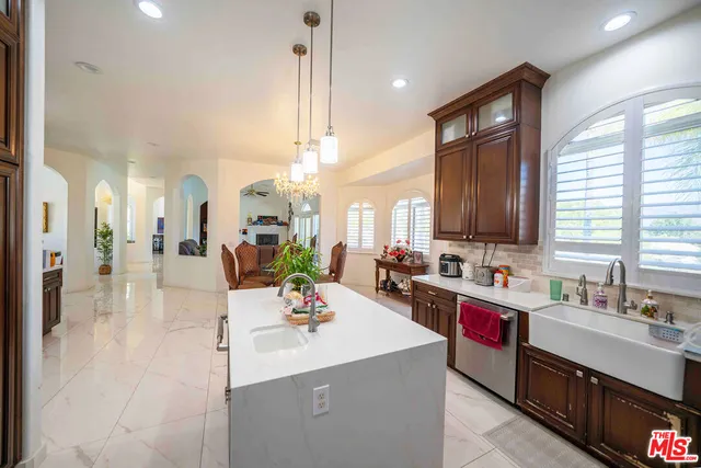 a view of kitchen with kitchen island wooden cabinets and living room view