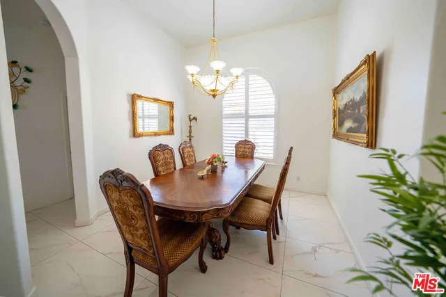 a living room with furniture flowers and a chandelier