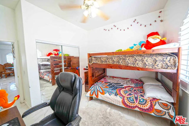 a bedroom with a large bed and two large window