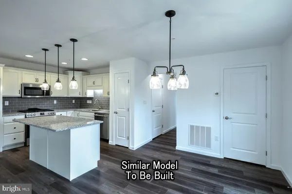a view of a kitchen with stainless steel appliances granite countertop a stove a sink dishwasher and a wooden floor