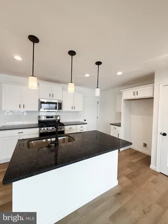 a kitchen with stainless steel appliances kitchen island sink refrigerator and stove