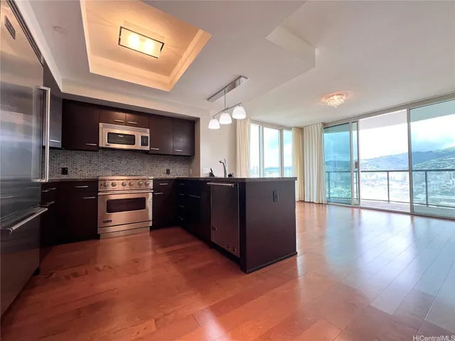 a kitchen with stainless steel appliances granite countertop a stove a sink and a microwave