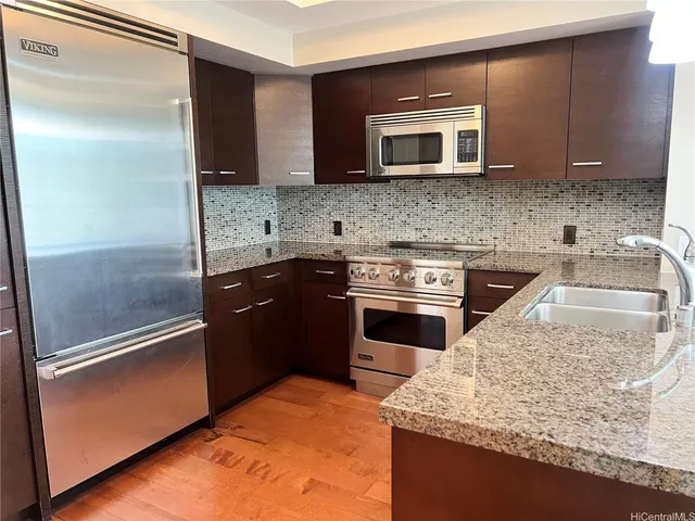 a kitchen with granite countertop stainless steel appliances and a sink