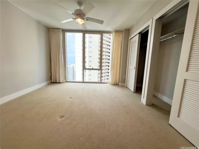 an empty room with windows and closet