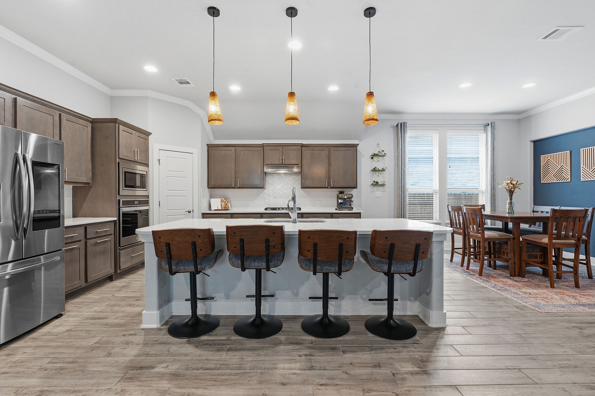 104 Red Granite Road Georgetown, TX 78633 - Photo 11 of 36 a kitchen with stainless steel appliances granite countertop a kitchen island a stove a refrigerator a sink a dining table and chairs