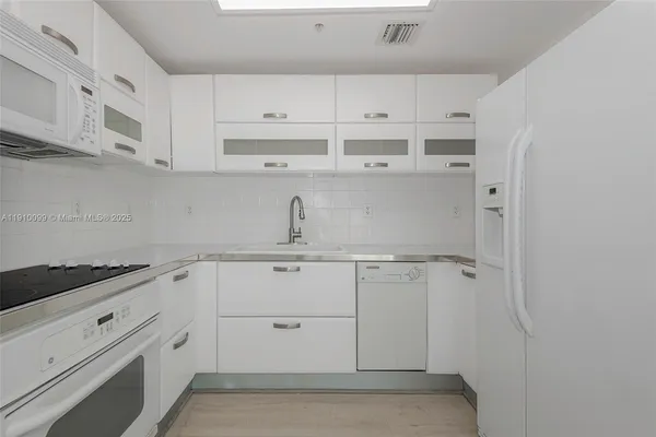 a kitchen with white cabinets and white appliances