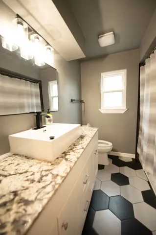 a bathroom with a granite countertop sink and a mirror