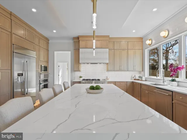 a kitchen with stainless steel appliances a table and chairs in it