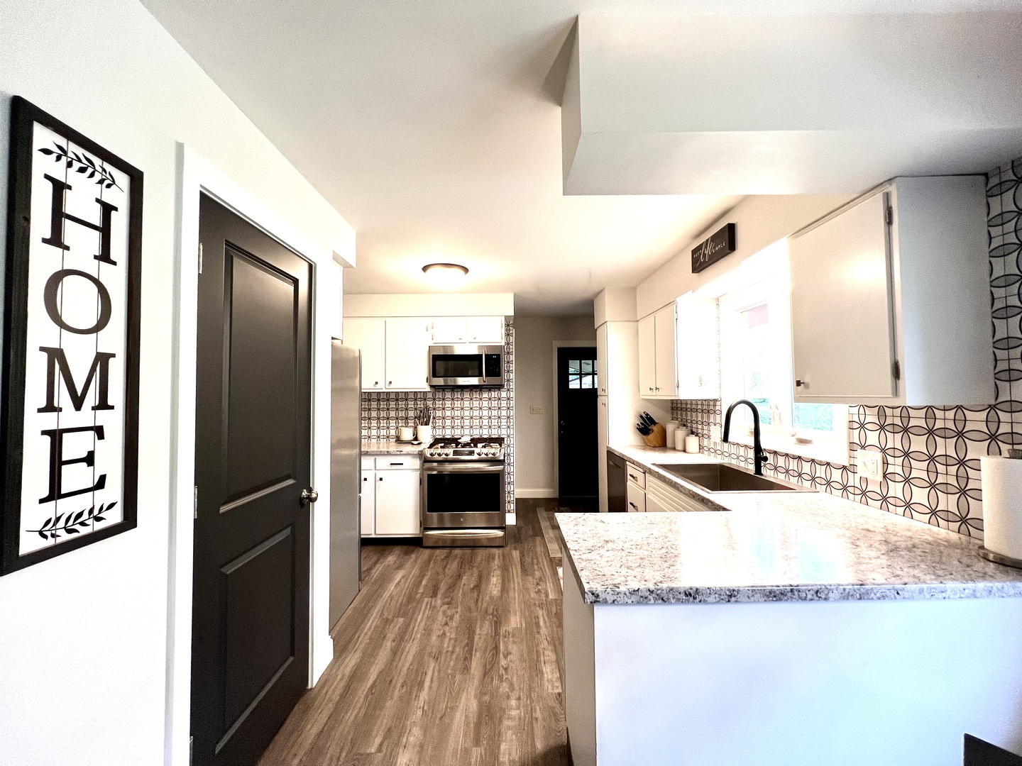 9128 North 1900 East Road Bloomington, IL 61705 - Photo 6 of 36 a kitchen with granite countertop a refrigerator a stove and a sink with wooden floor