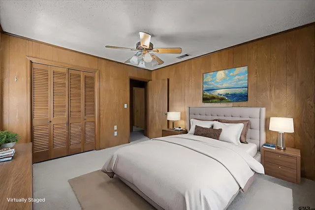 a bedroom with a large bed and a chandelier