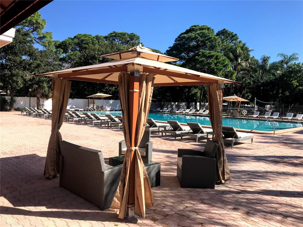 2630 Coconut Bay Lane, Unit 618 (61I) Sarasota, FL 34237 - Photo 18 of 29 a view of a patio with table and chairs a barbeque with wooden fence