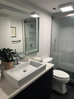 a bathroom with a sink a toilet and shower
