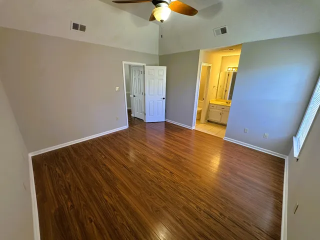 a view of empty room with wooden floor