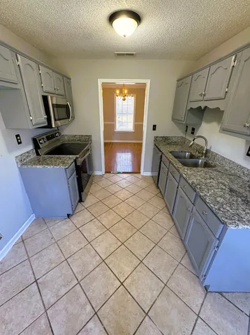 a kitchen with stainless steel appliances granite countertop a sink stove and cabinets