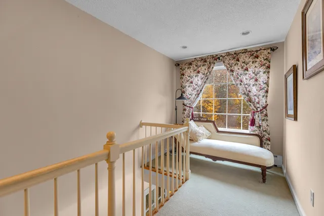 a view of a bedroom with wooden floor and white walls
