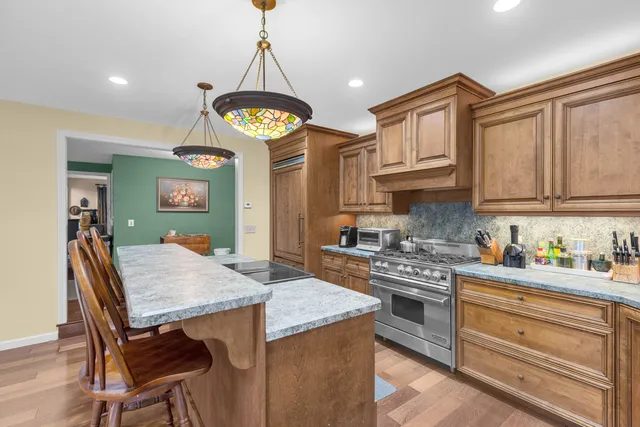 a kitchen with stainless steel appliances granite countertop a stove a sink dishwasher and cabinets with wooden floor
