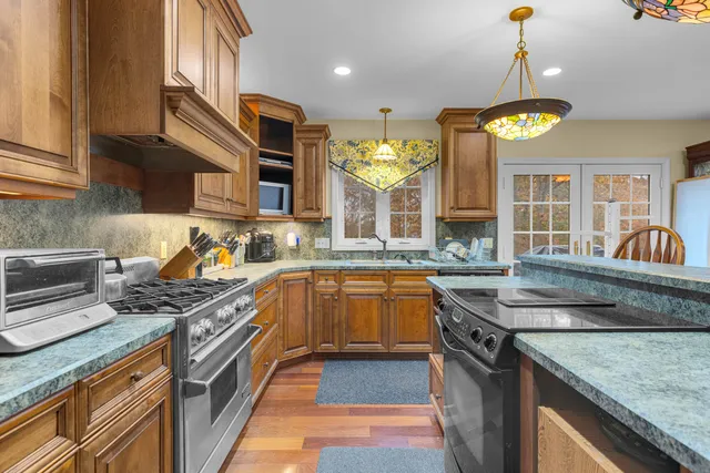 a kitchen with stainless steel appliances granite countertop a stove a sink and a refrigerator