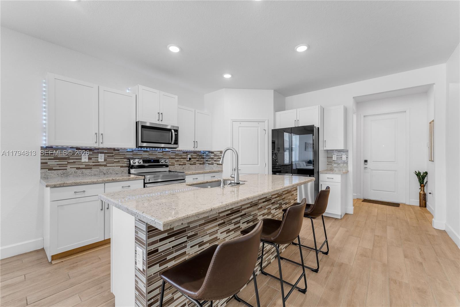 13225 Southwest 272nd Street Homestead, FL 33032 - Photo 7 of 44 a kitchen with stainless steel appliances a stove a sink a microwave a refrigerator and cabinets