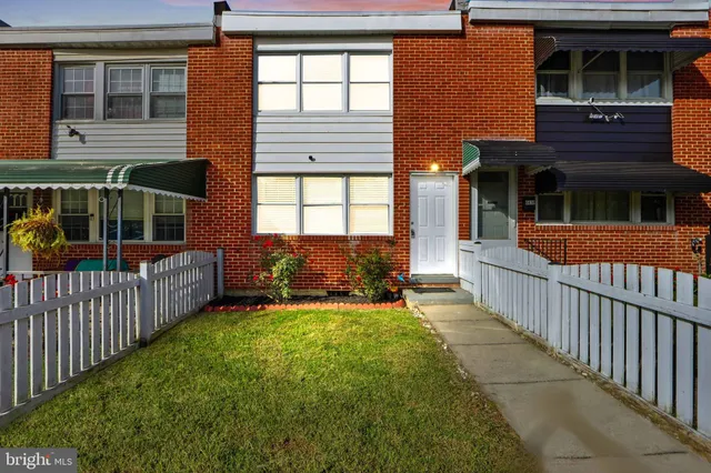a view of a house with a yard and wooden fence