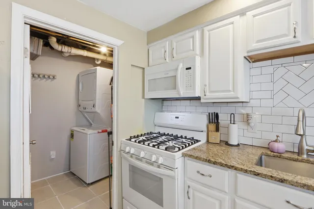 a kitchen with stainless steel appliances granite countertop a sink and a refrigerator