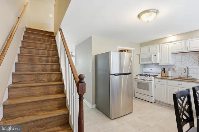 a view of kitchen with sink and refrigerator
