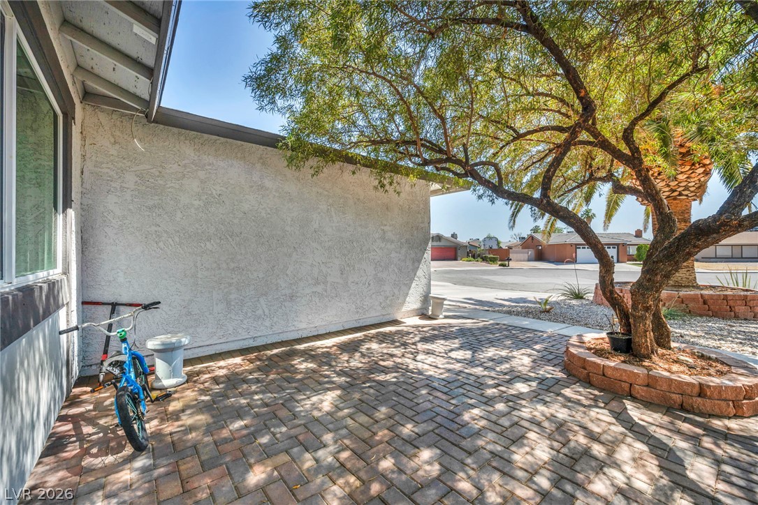 5882 Rio Tinto Way Las Vegas, NV 89110 - Photo 8 of 56 A neatly paved patio area, shaded by mature trees, enhances outdoor living.