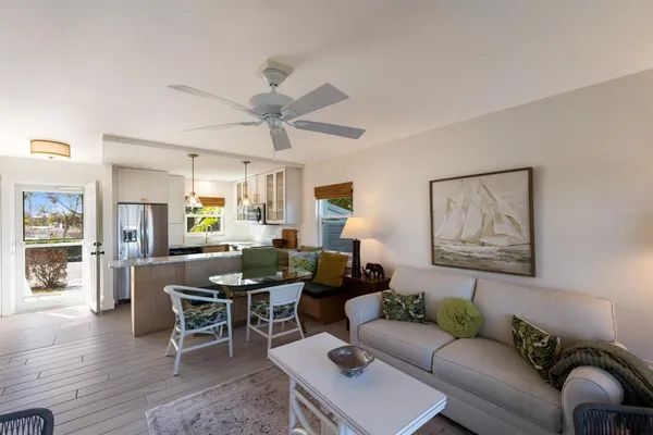 a living room with furniture a wooden floor and a chandelier
