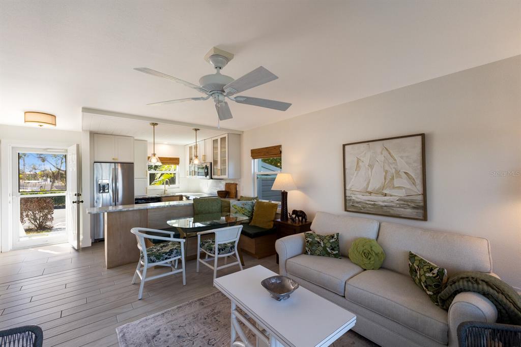 5850 Gasparilla Road, Unit M7 Boca Grande, FL 33921 - Photo 13 of 54 a living room with furniture a wooden floor and a chandelier