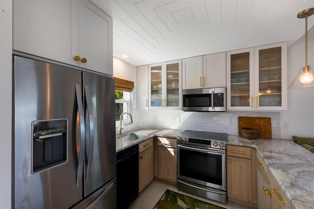 5850 Gasparilla Road, Unit M7 Boca Grande, FL 33921 - Photo 6 of 54 a kitchen with stainless steel appliances granite countertop a refrigerator and a stove