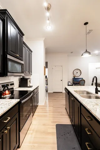 a kitchen with stainless steel appliances granite countertop a sink stove and refrigerator