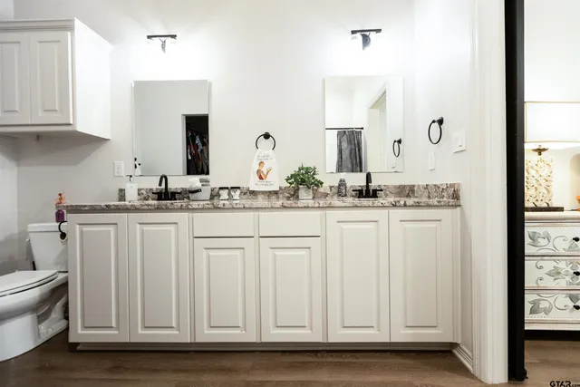 a bathroom with white cabinets and sink