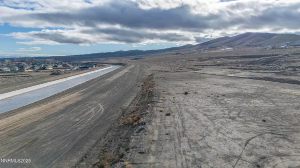 a view of a dry yard with wooden fence