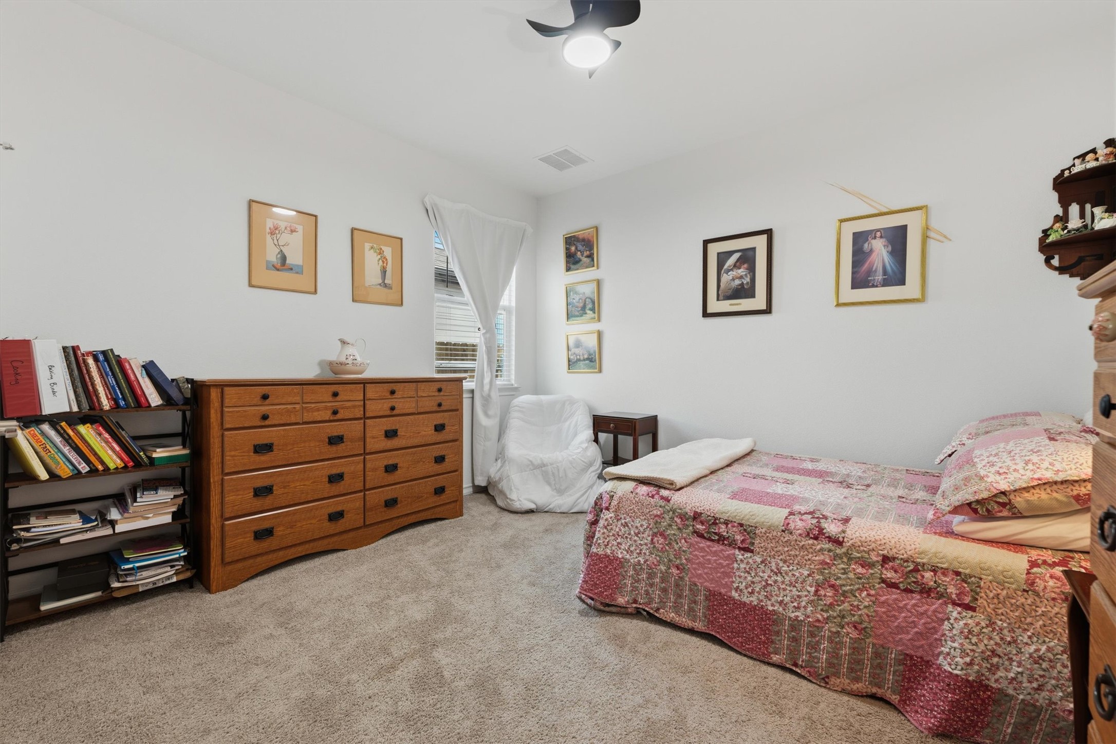 1000 Moose Road Hutto, TX 78634 - Photo 16 of 29 a bedroom with a bed a dresser and book shelf