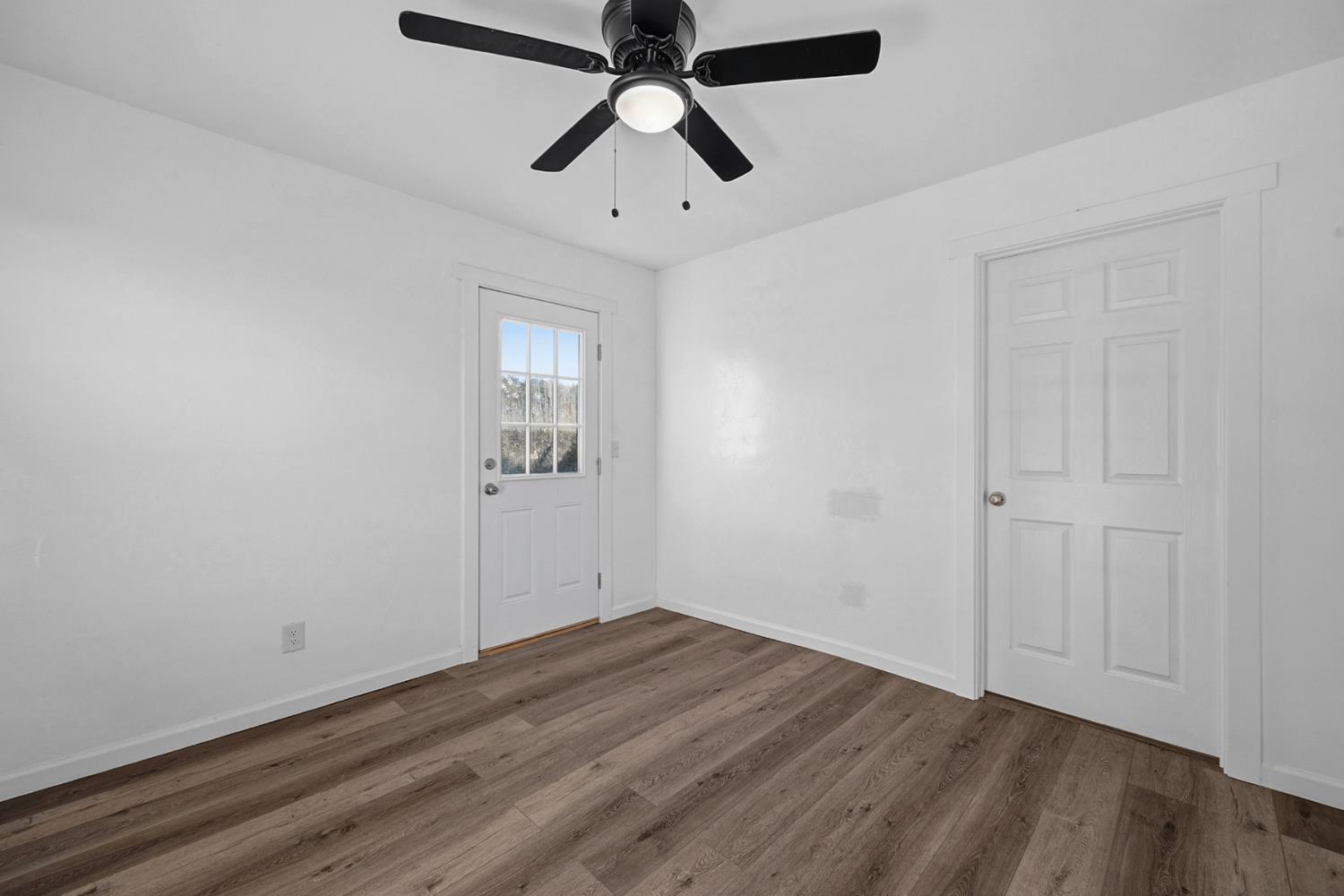 29205 Road 210 Exeter, CA 93221 - Photo 38 of 44 an empty room with wooden floor ceiling fan and windows