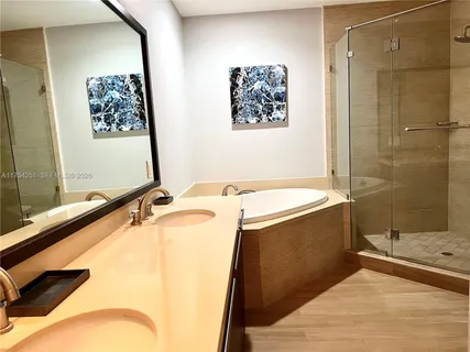 a bathroom with a tub a sink and a shower