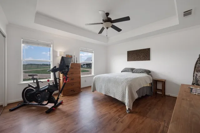 a bedroom with a bed a flat screen tv and a dresser