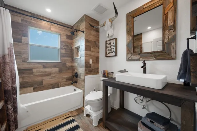 a bathroom with a sink a toilet a mirror and bathtub