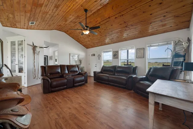 a living room with furniture a ceiling fan and a rug