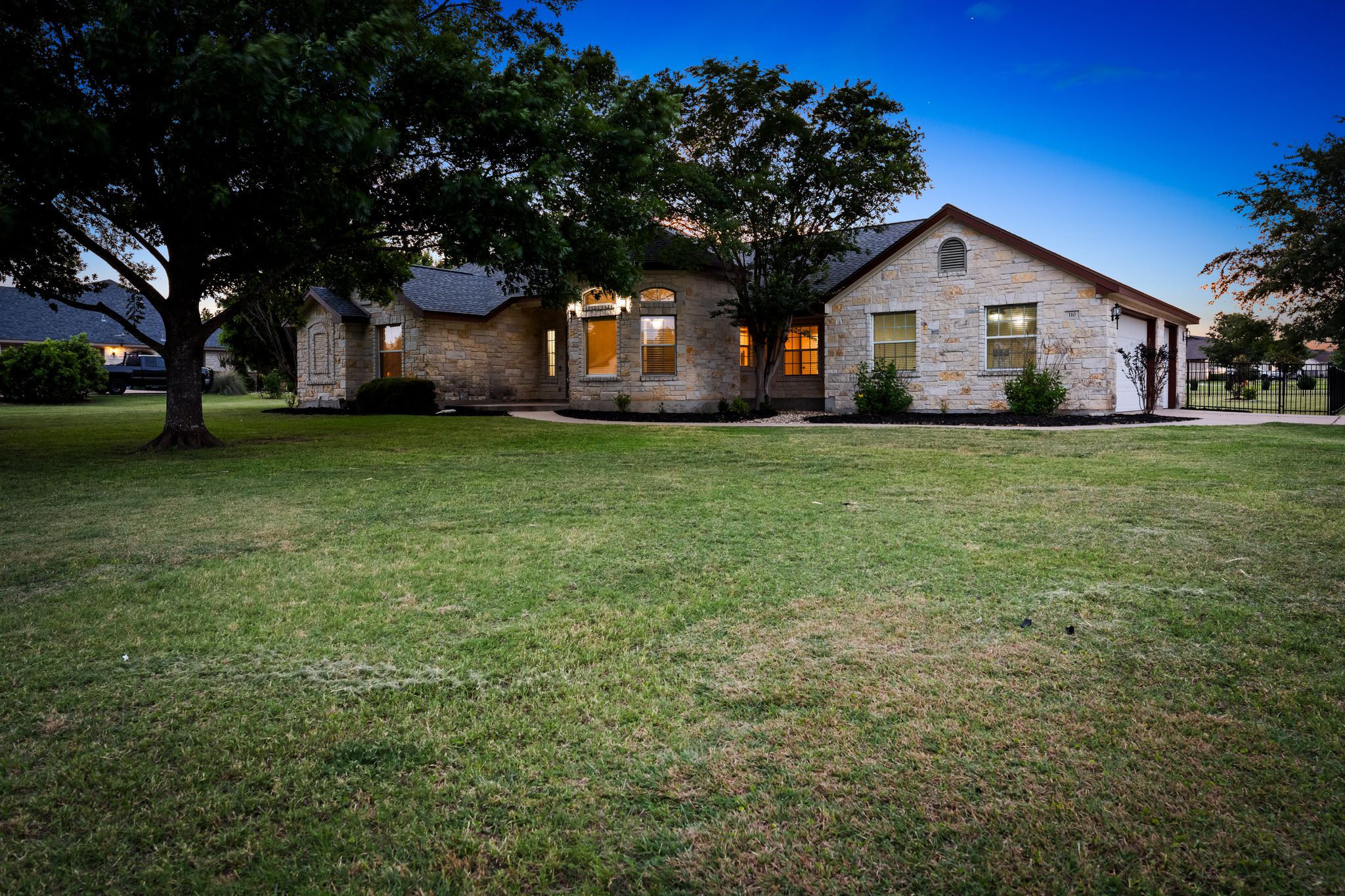 110 Starlight Trail Georgetown, TX 78633 - Photo 31 of 36 Ranch-style house with stone siding, a garage, and a front lawn