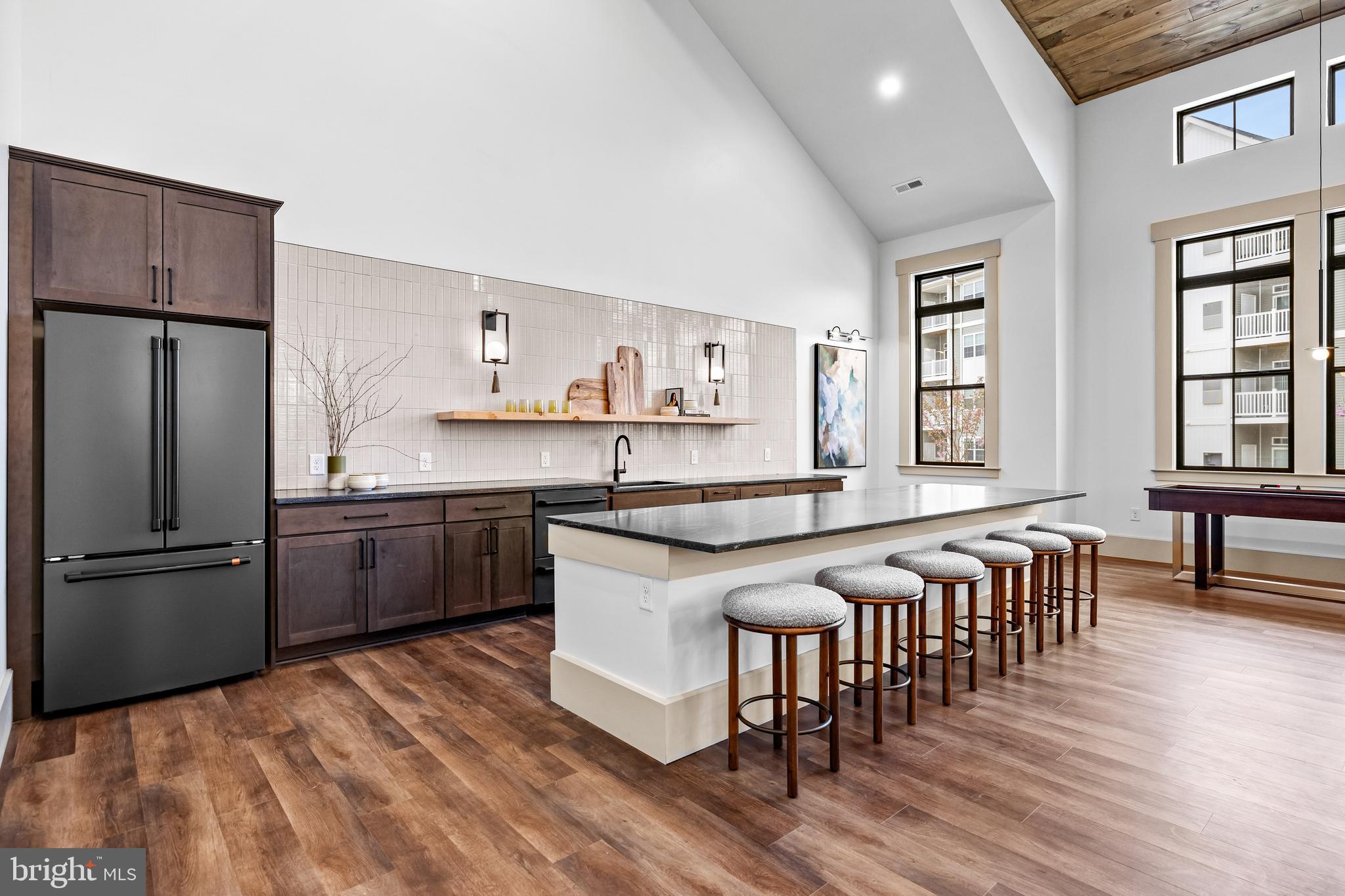 1201 Walnut Bottom Road, Unit 9202 Carlisle, PA 17015 - Photo 24 of 33 a kitchen with stainless steel appliances granite countertop a refrigerator a stove a sink a dining table and chairs with wooden floor