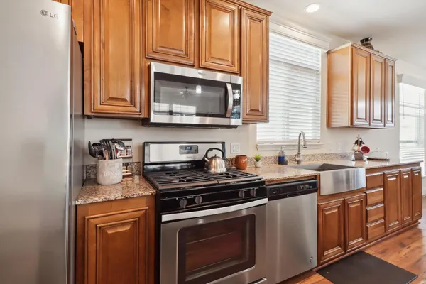 a kitchen with stainless steel appliances granite countertop a sink stove and microwave