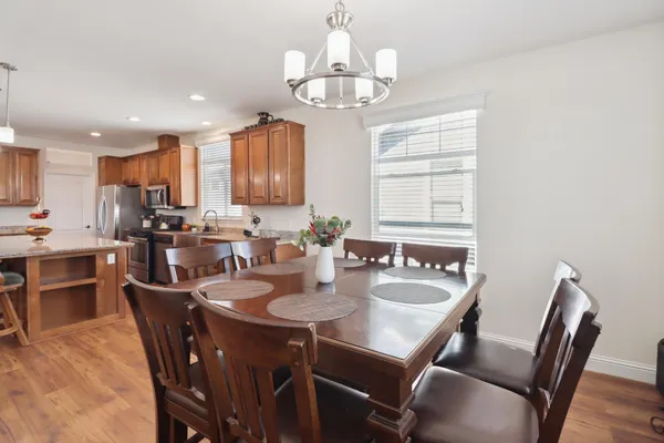 a kitchen with a dining table chairs stainless steel appliances and cabinets