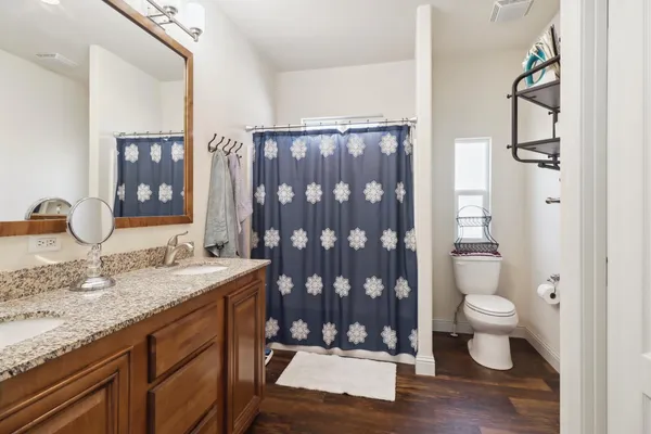 a bathroom with a granite countertop sink toilet and shower