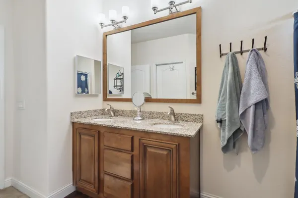 a bathroom with a granite countertop sink and a mirror
